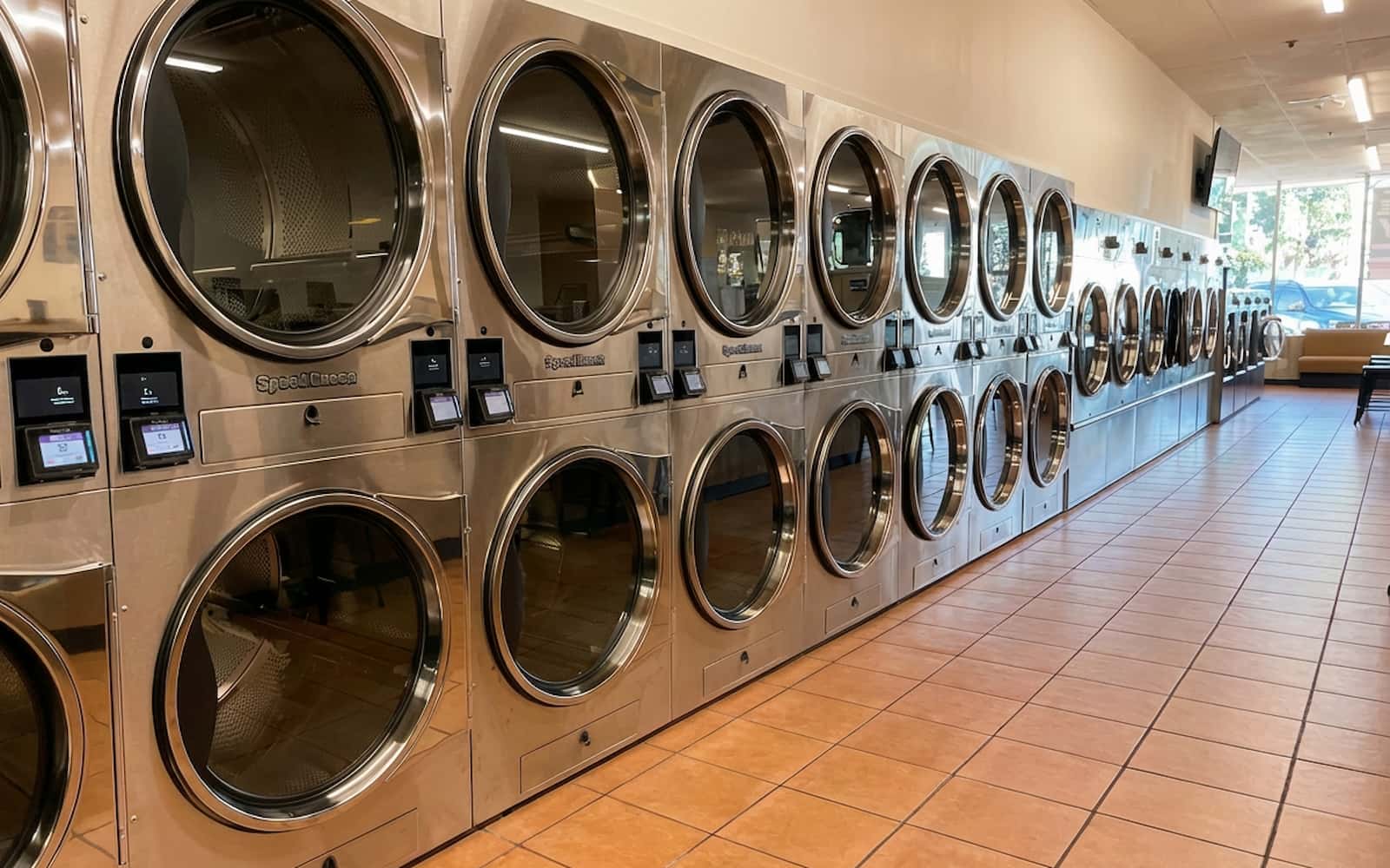 Rows of stainless steel coinless washers and dryers in several sizes at Polanco Laundry in Arleta